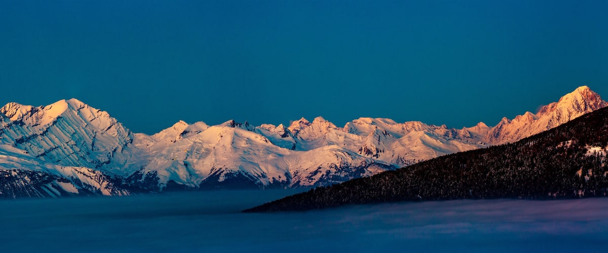 Snow-covered mountain peaks under a clear blue sky.