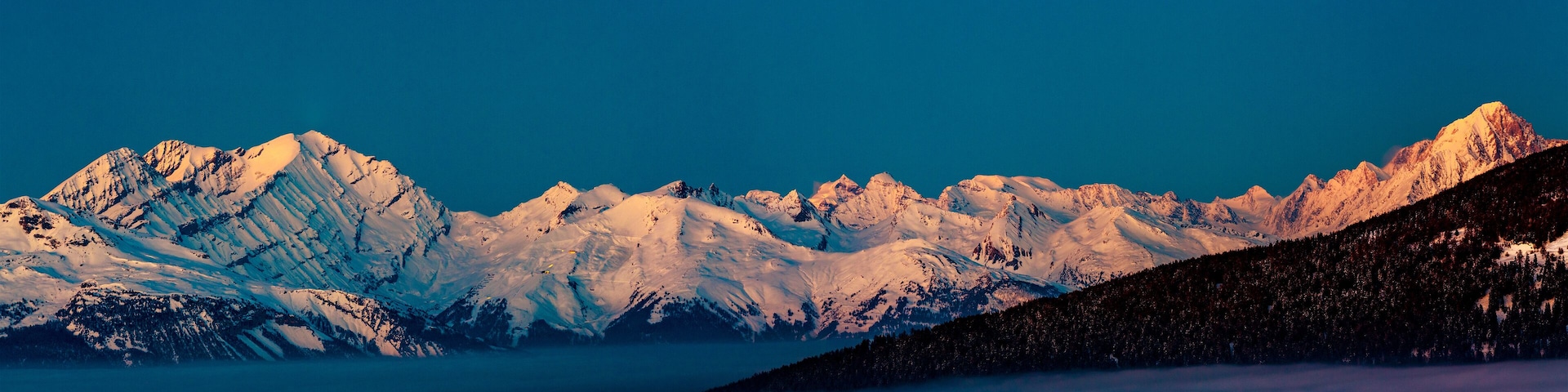 Snow-covered mountain peaks under a clear blue sky.