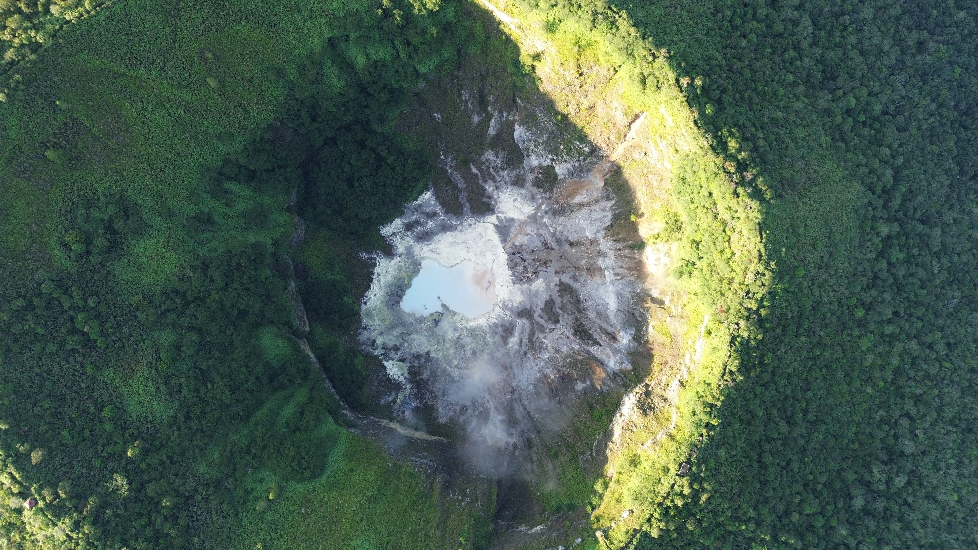 A volcanic crater surrounded by dense forest.