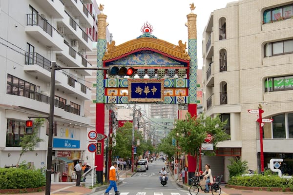 A street with a colorful archway, buildings, and a sign with Chinese characters.