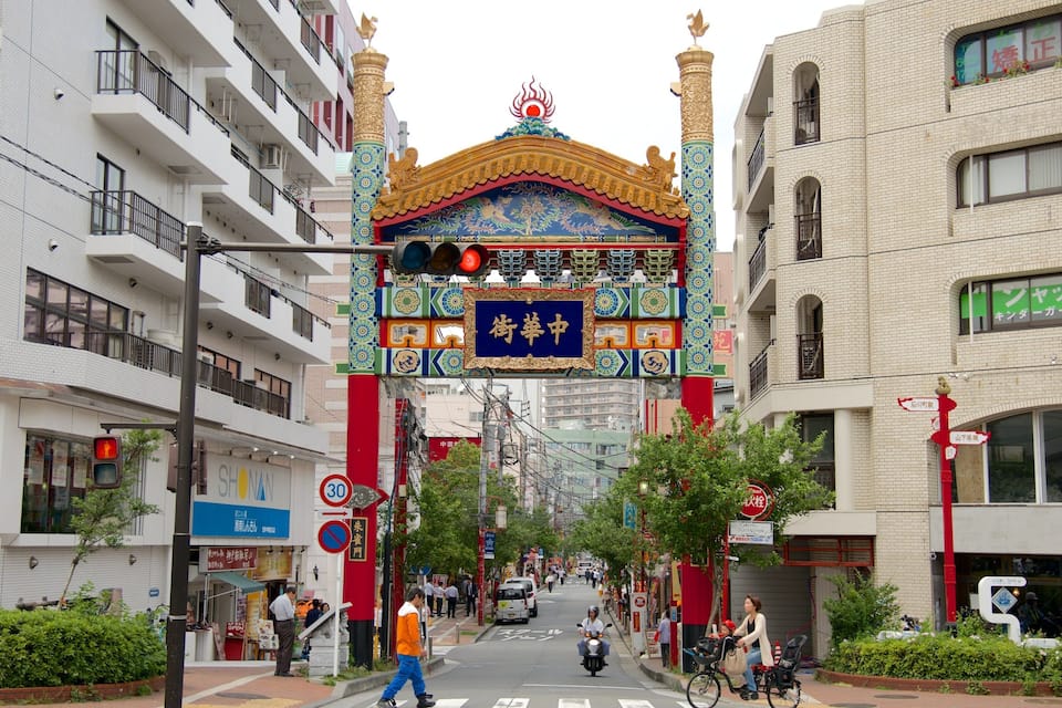 A street with a colorful archway, buildings, and a sign with Chinese characters.