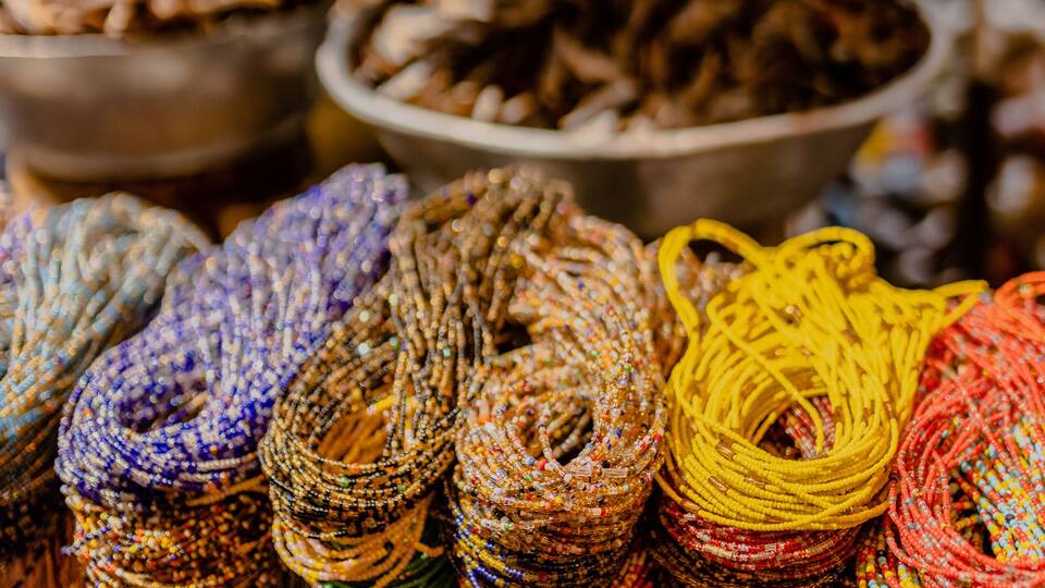 Colorful woven baskets and textiles displayed at a market stall.