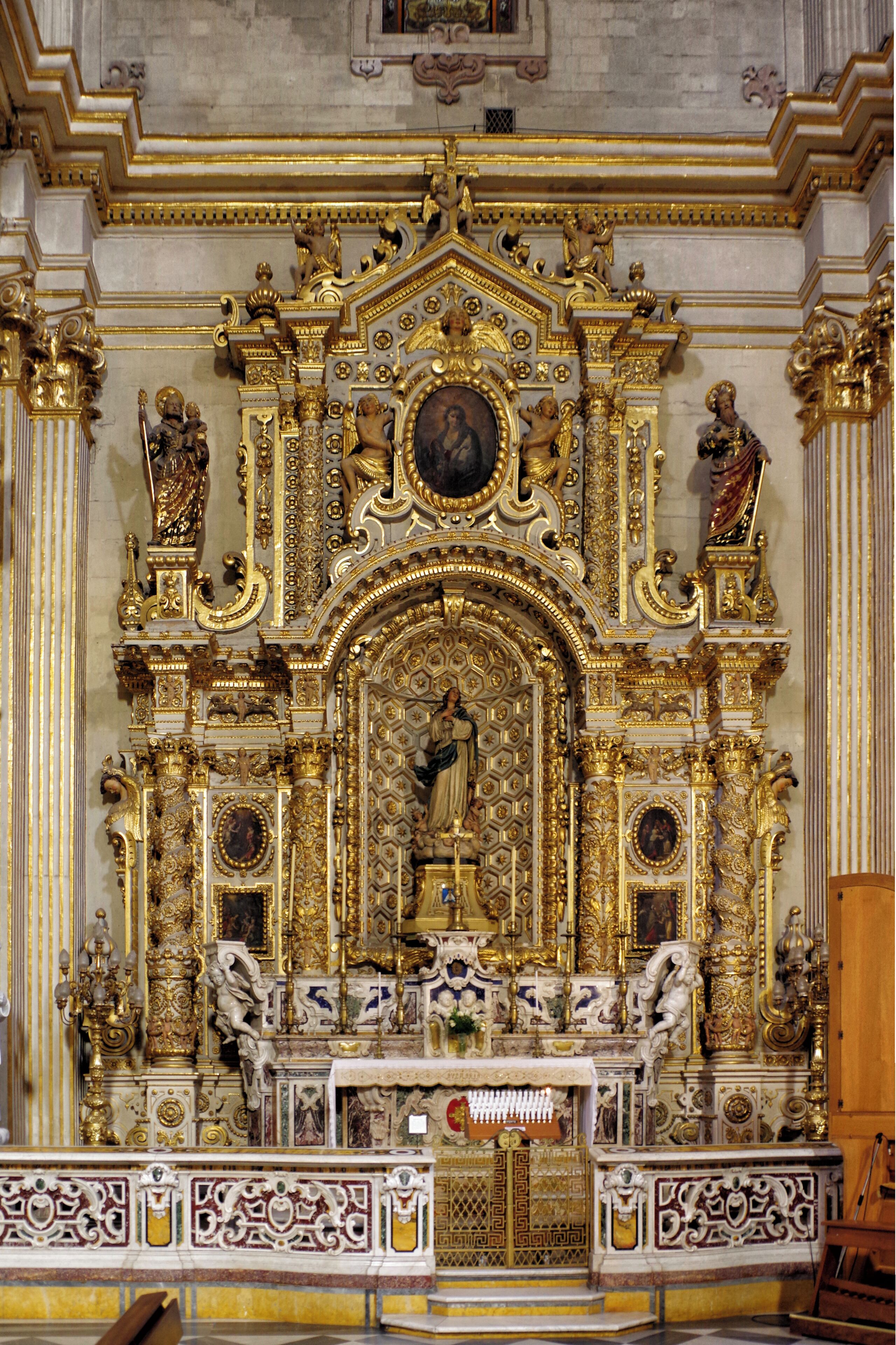 Un altar religioso ornamentado con detalles dorados y estatuas.