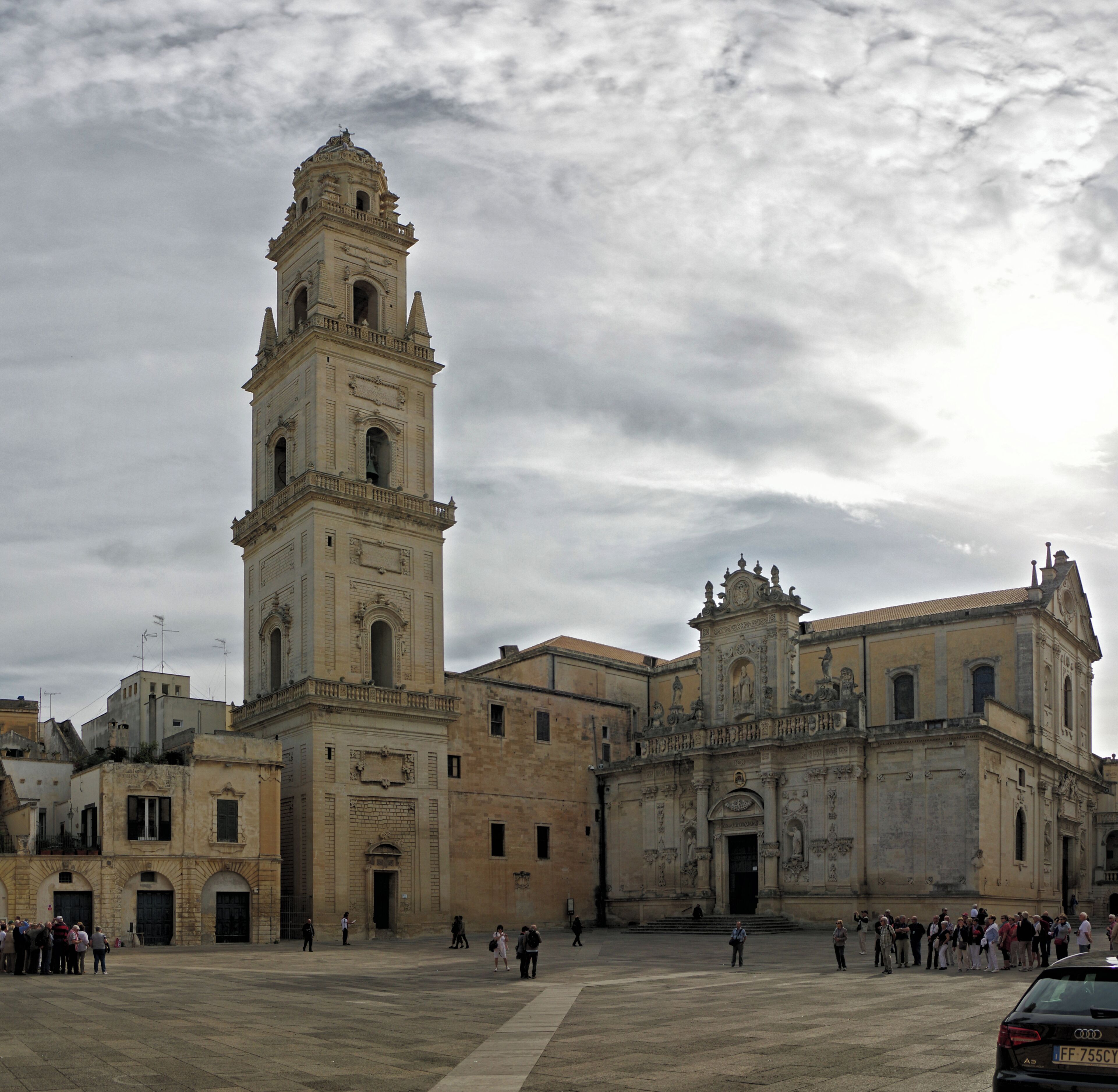 A historic square with a prominent bell tower and a cathedral.