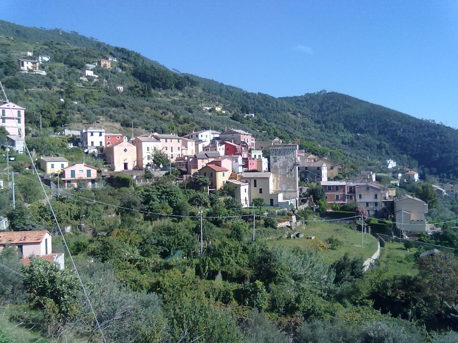 A hillside village with colorful buildings nestled among lush greenery.