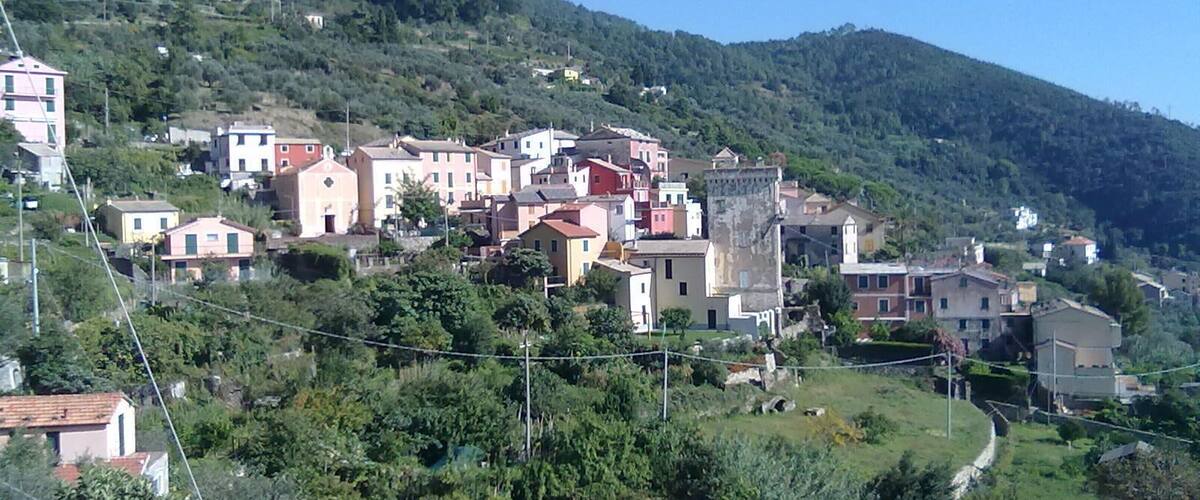 A hillside village with colorful buildings nestled among lush greenery.
