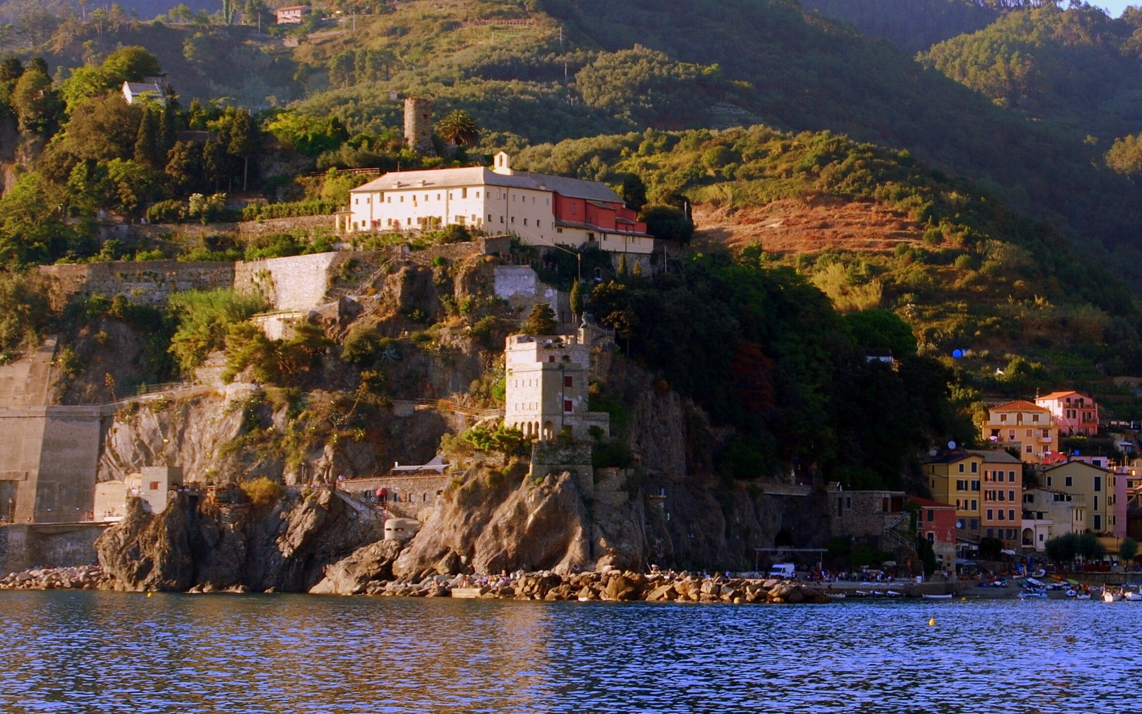 Uma vila costeira com edifícios numa colina com vista para o mar.
