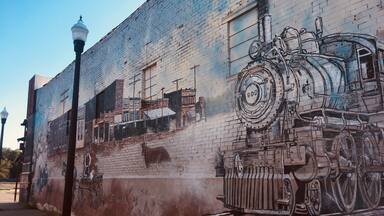 A mural of a train on a brick wall.