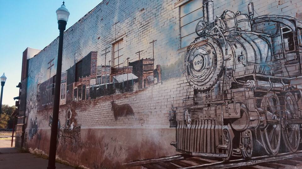 A mural of a train on a brick wall.