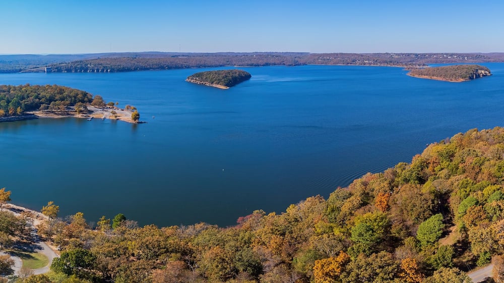 A large lake surrounded by forested hills.