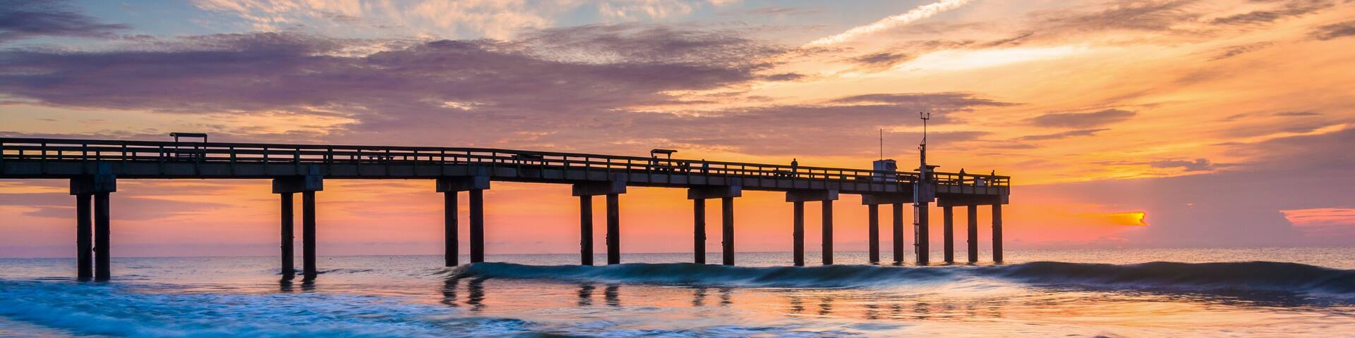 Waves on the Atlantic Ocean and fishing pier at sunrise, St. Aug