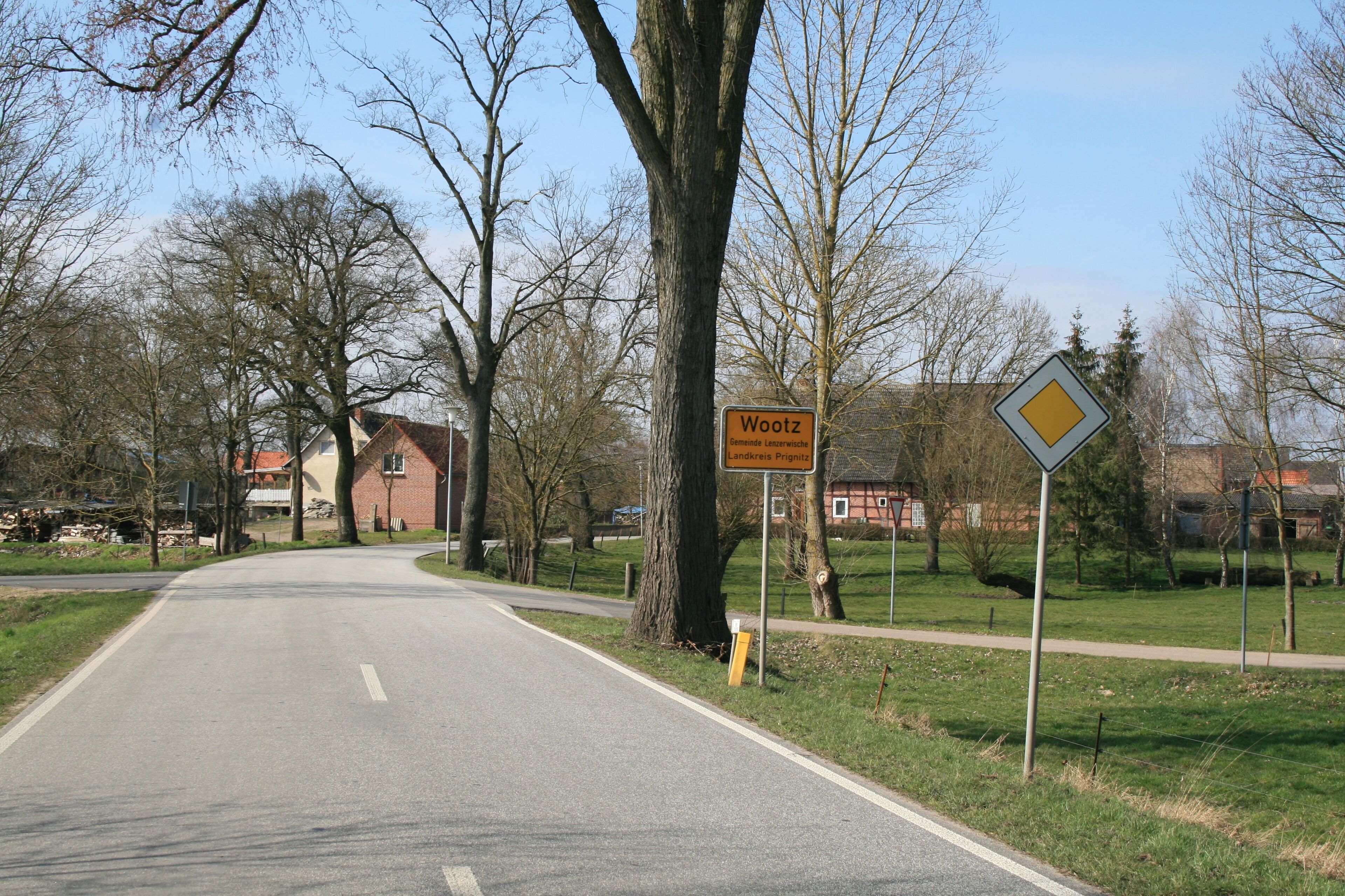A road with a sign reading 'Wootz' and 'Gemeinde Landkreises Prignitz'.