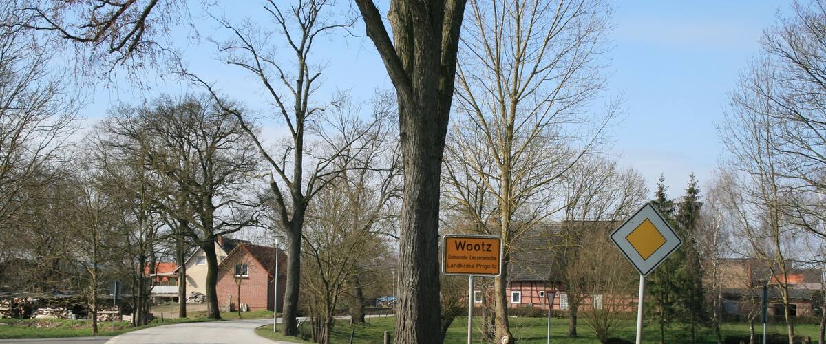 A road with a sign reading 'Wootz' and 'Gemeinde Landkreises Prignitz'.
