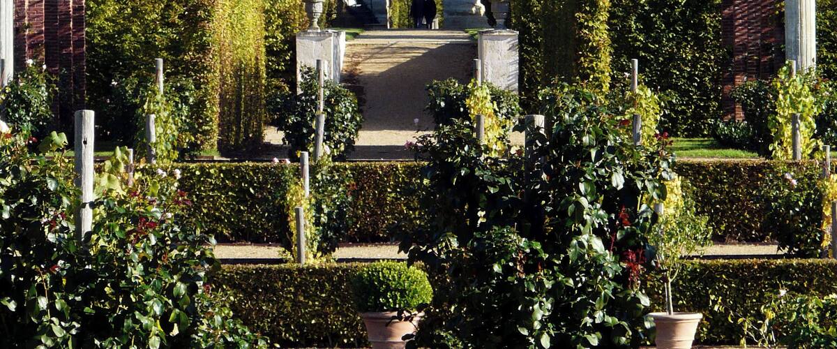 A garden with a gazebo, brick structures, and lush greenery.