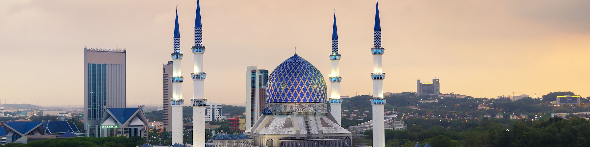 Uma mesquita com uma grande cúpula azul e quatro minaretes altos.