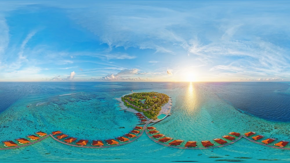 Luxurious overwater villas on Alimatha Island in the Maldives, Vaavu Atoll, at sunset. Aerial seamless 360 degree spherical panorama