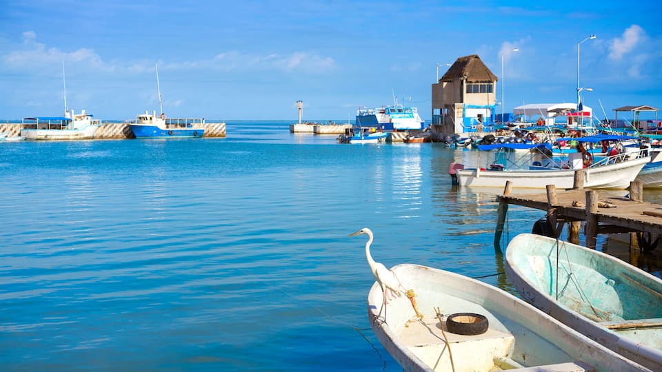 A harbor with boats, a small hut, and calm blue waters.