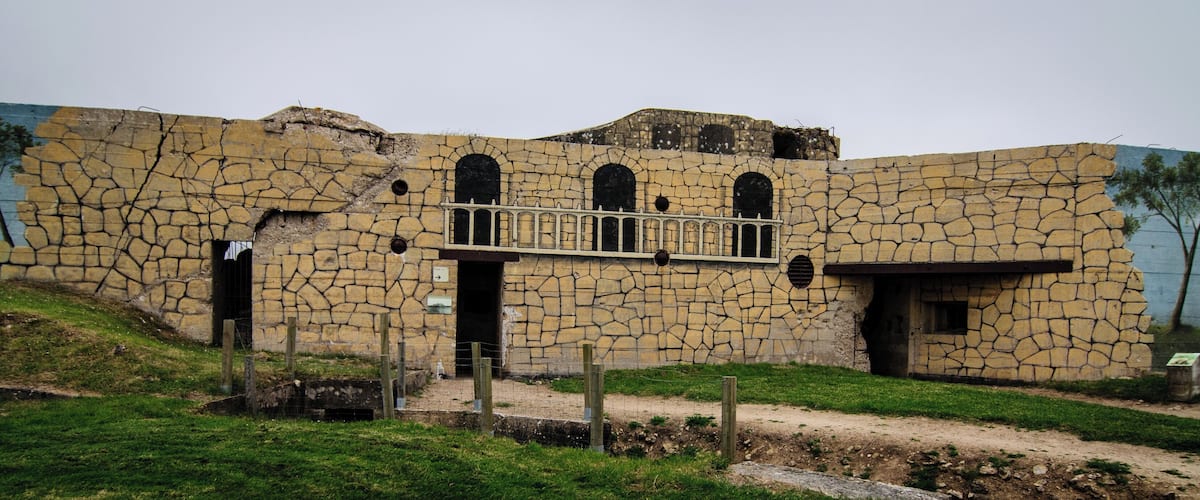 A stone building with a balcony and arched windows.