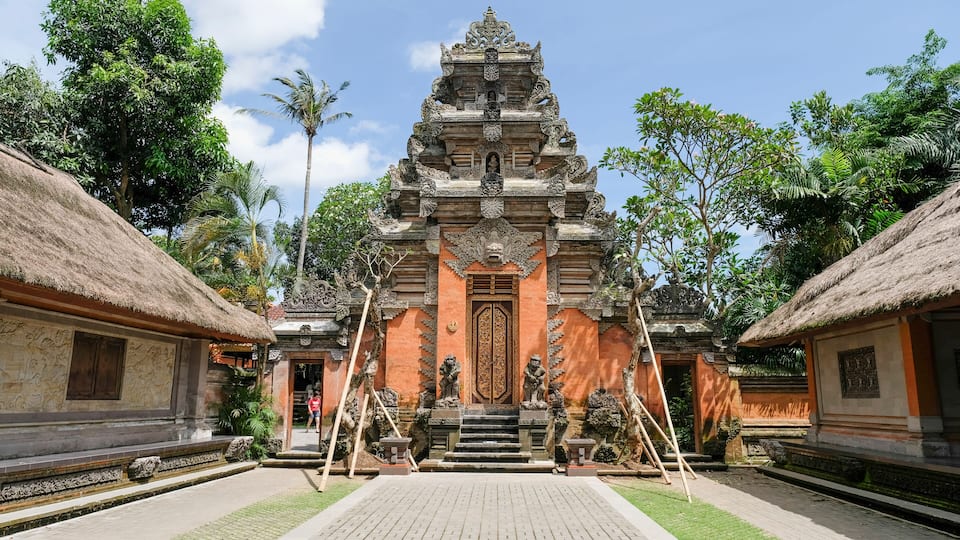 A traditional Balinese temple with intricate carvings and a thatched roof.