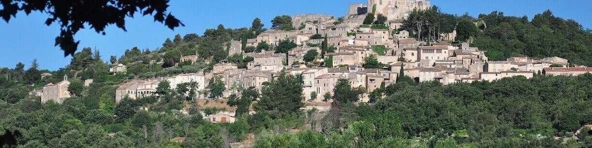 A hillside town with historic buildings and a castle on top.