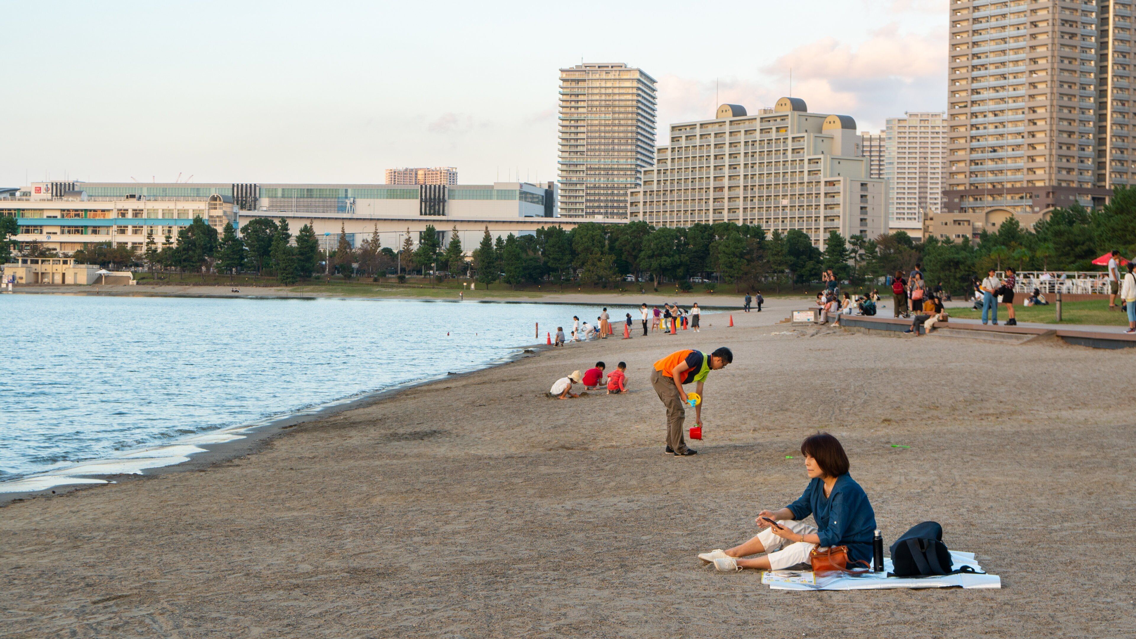 Odaiba Beach Park which includes a sunset, a river or creek and a beach