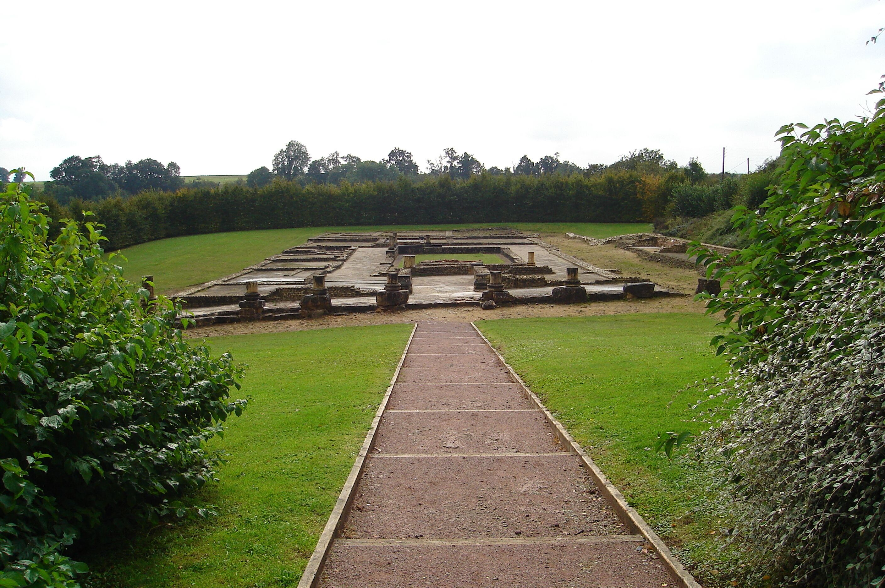 A historical site with ruins and a pathway leading through it.