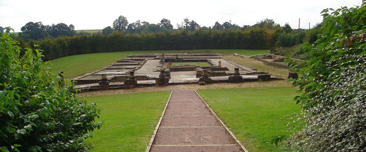 A historical site with ruins and a pathway leading through it.