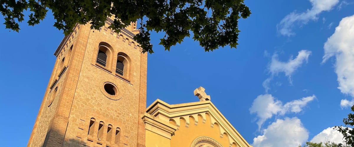 A historic church with a tall bell tower and a large banner.