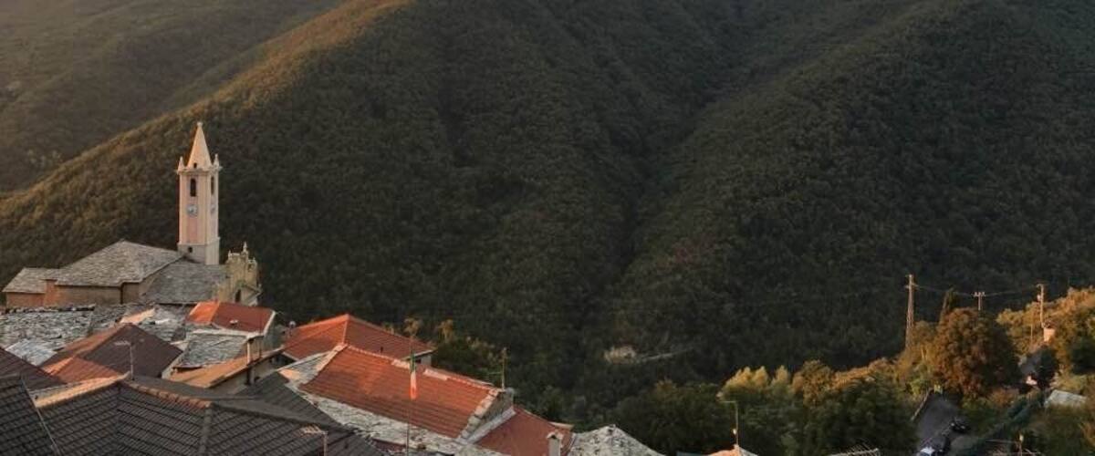 A mountainous landscape with a church and residential buildings.