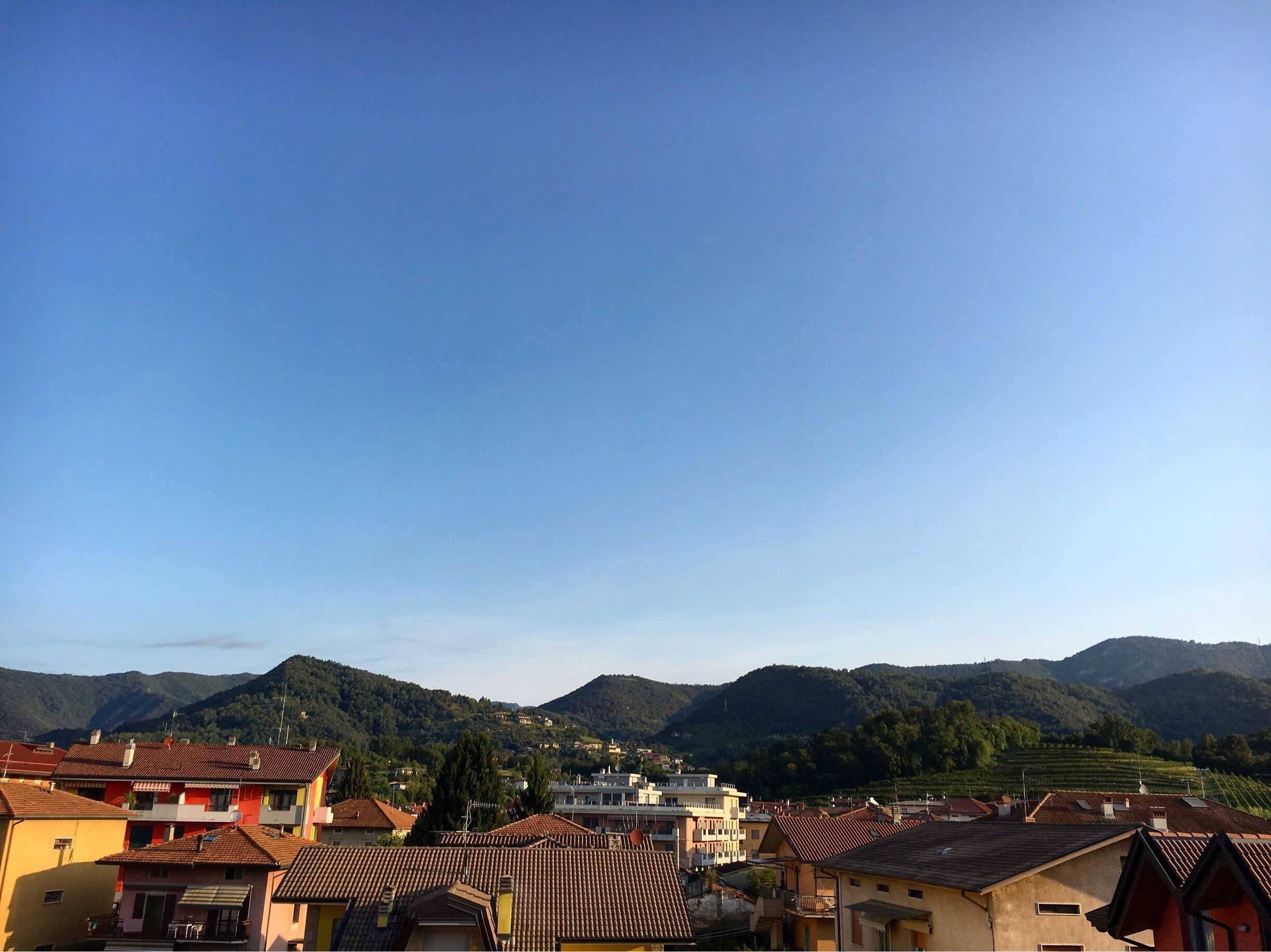 A town with colorful buildings and a mountainous backdrop.