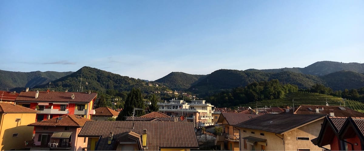 A town with colorful buildings and a mountainous backdrop.