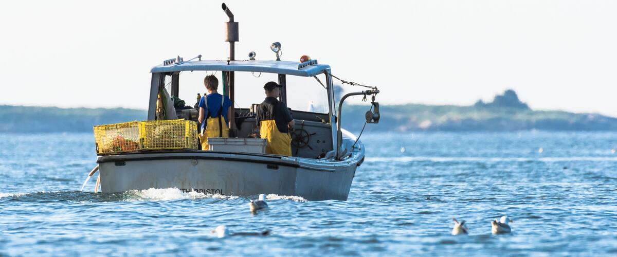 Lobster men hard at work on a beautiful morning in early autumn in South Bristol, Maine, United States