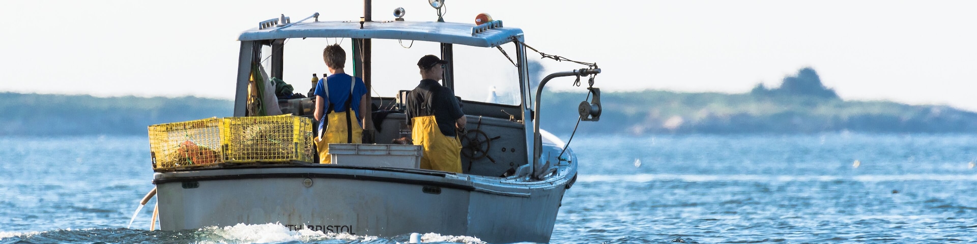 Lobster men hard at work on a beautiful morning in early autumn in South Bristol, Maine, United States