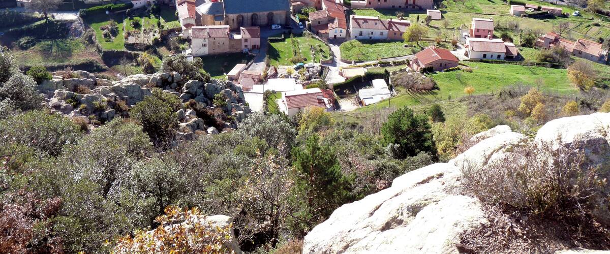 A village with a prominent church, surrounded by rolling hills and vineyards.