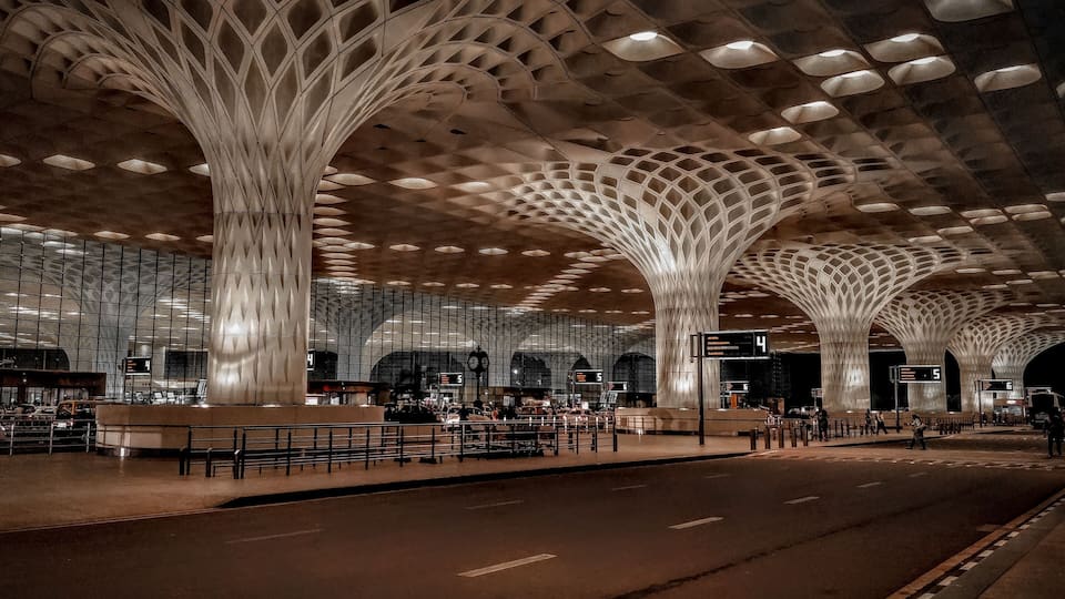 Ein moderner Bahnhof mit markanten, baumartigen Säulen und einem großzügigen Bahnsteigbereich.
