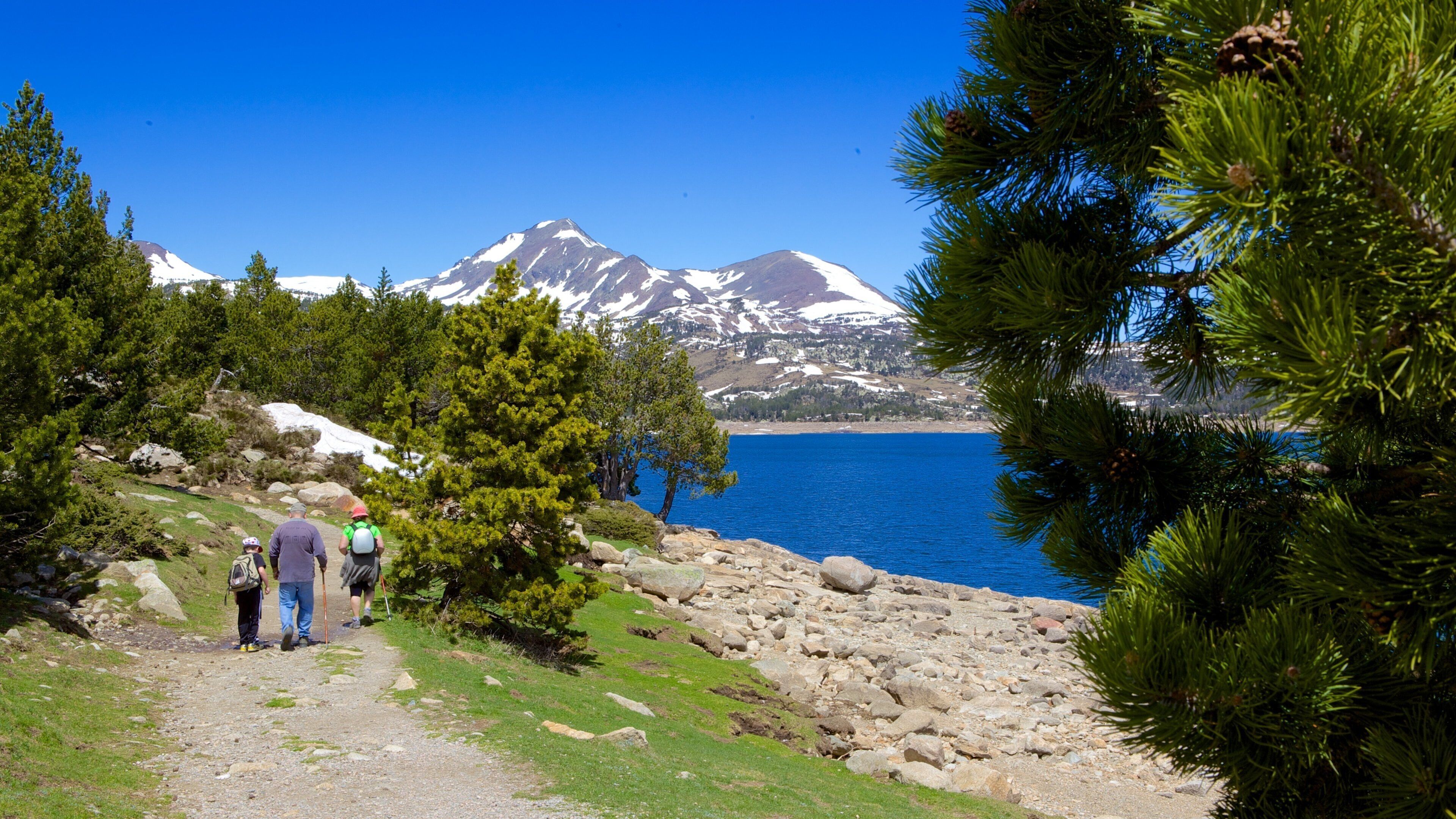 A hiking trail with a mountain in the background and a body of water in the foreground.