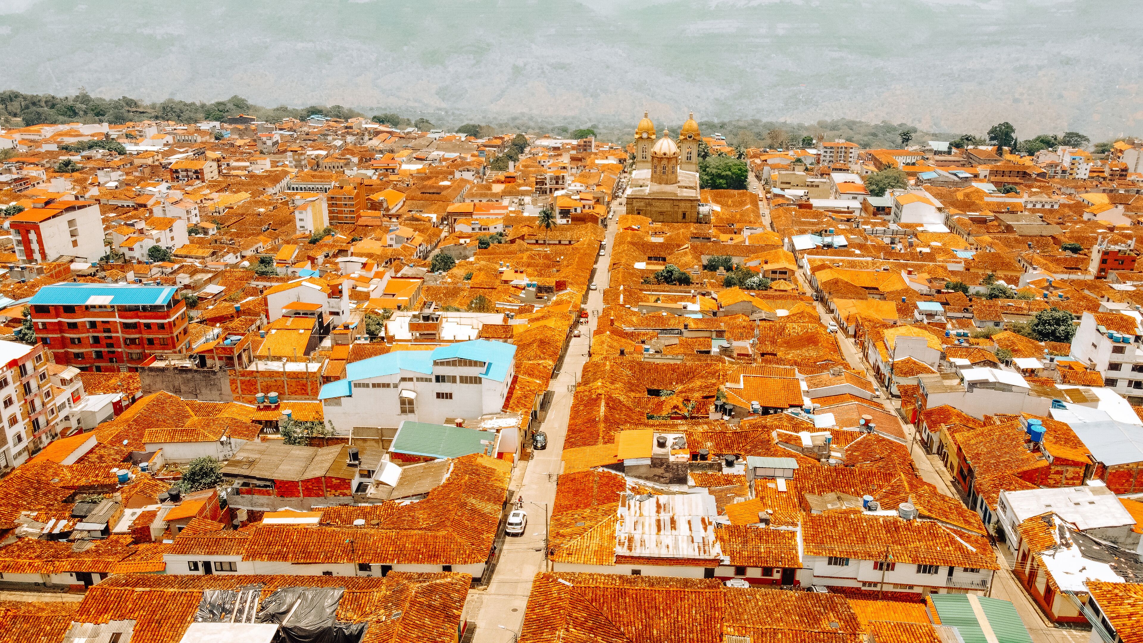 A densely packed urban area with numerous buildings featuring orange-tiled roofs.