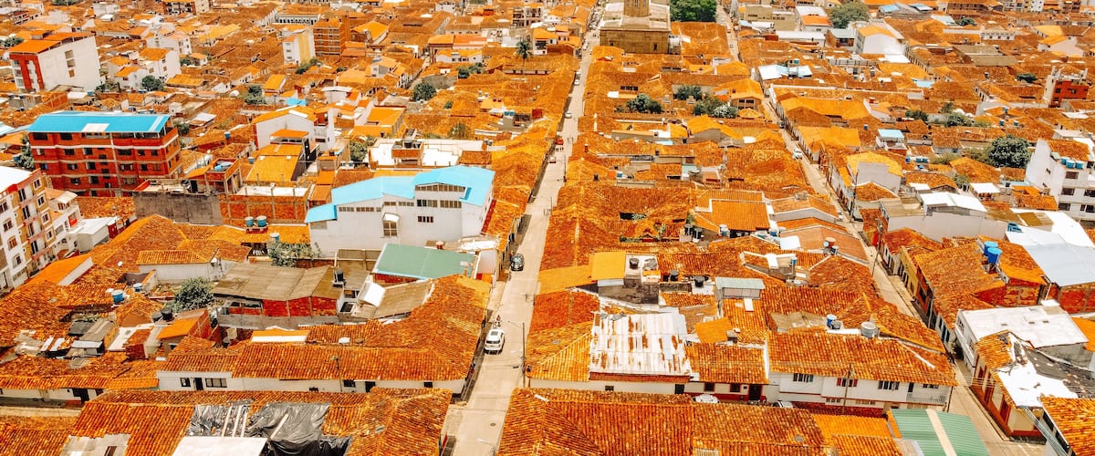 A densely packed urban area with numerous buildings featuring orange-tiled roofs.