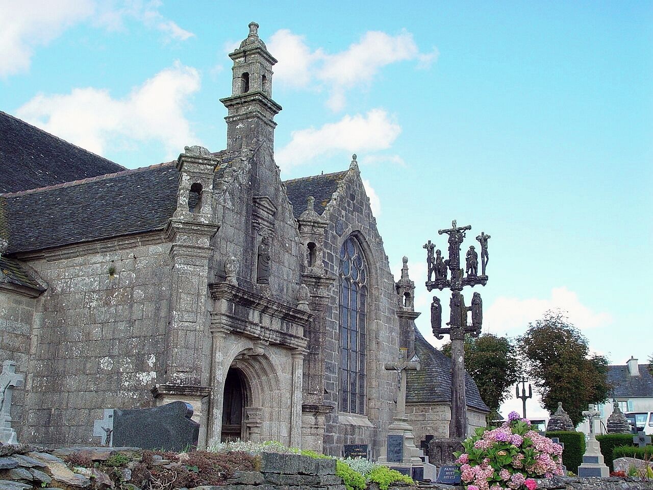 A historic stone church with a tall bell tower and a large arched entrance.