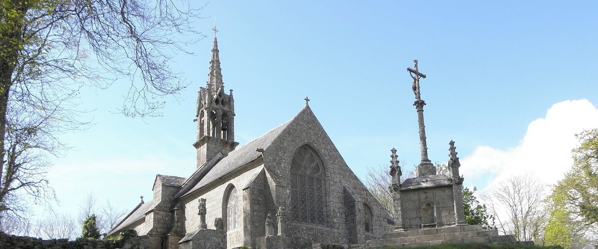 A historic church with a tall spire and a large arched window.