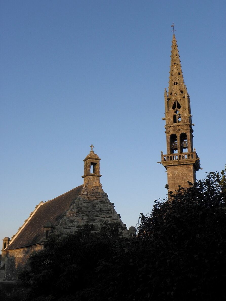 A church with a tall bell tower and a smaller steeple.