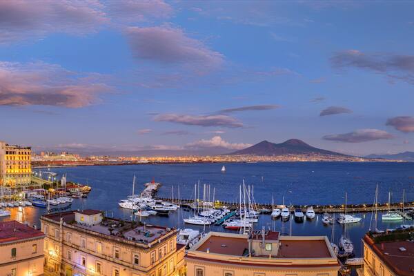 Naples, Italy. Splendid panoramic view from Castel dell'Ovo over the city and Borgo Marinari after sunset. Marina on Via Partenope with luxury hotels. Mount Vesuvius in the distance. 2012-12-19.