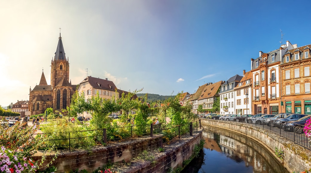 A historic town with a church, a canal, and traditional European architecture.