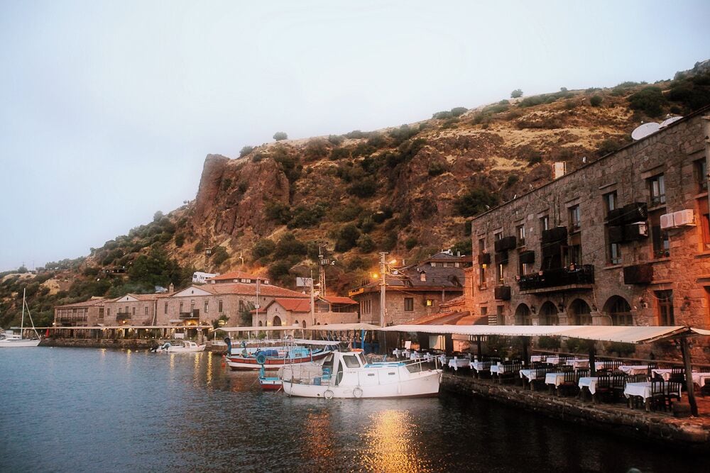Located on the south western coast of Canukkale in Turkey, Assos, whose ancient name is Behramkale, has views of the Greek Island of Lesbos, on the Aegean.

The quiet coastal town is quaint and walking in the early morning (which is when this photo was taken) not only gives you the most spectacular sunrise, but lets you see the fishermen prepare before they set out for the day. 

Definitely one of my most favorite places to visit in Turkey.