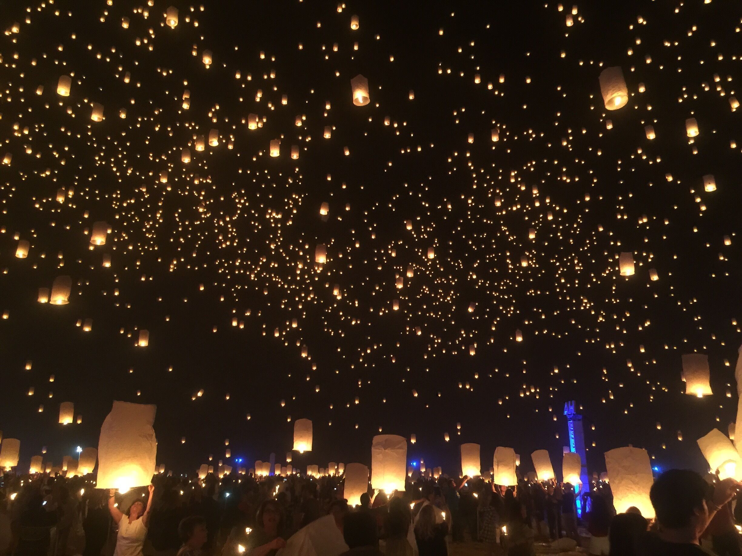 A night sky filled with numerous lanterns being released.