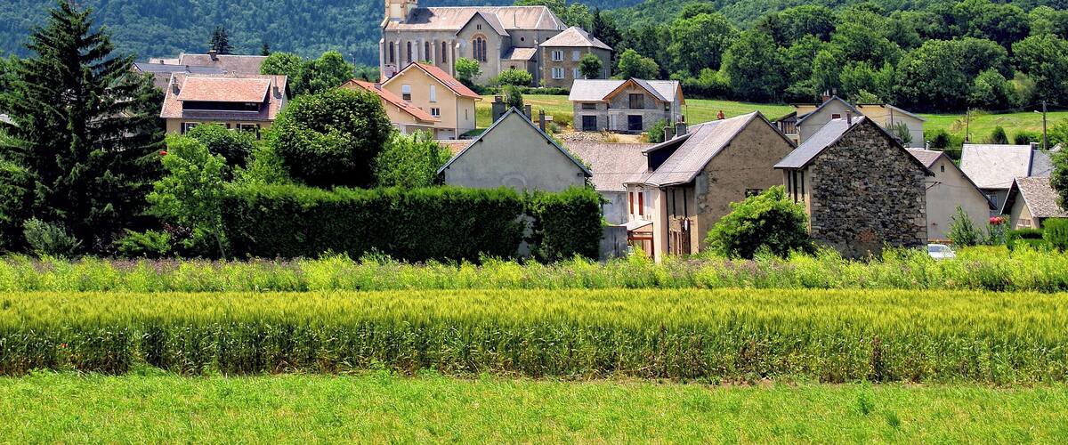 A village with a church, houses, and a mountain in the background.