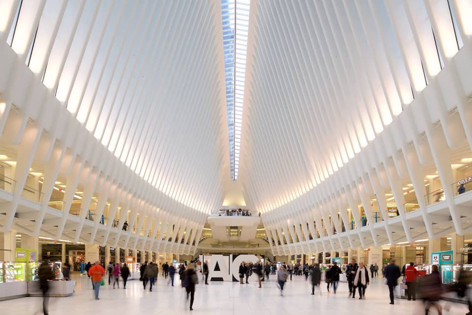A spacious indoor area with a high ceiling and rows of white columns.