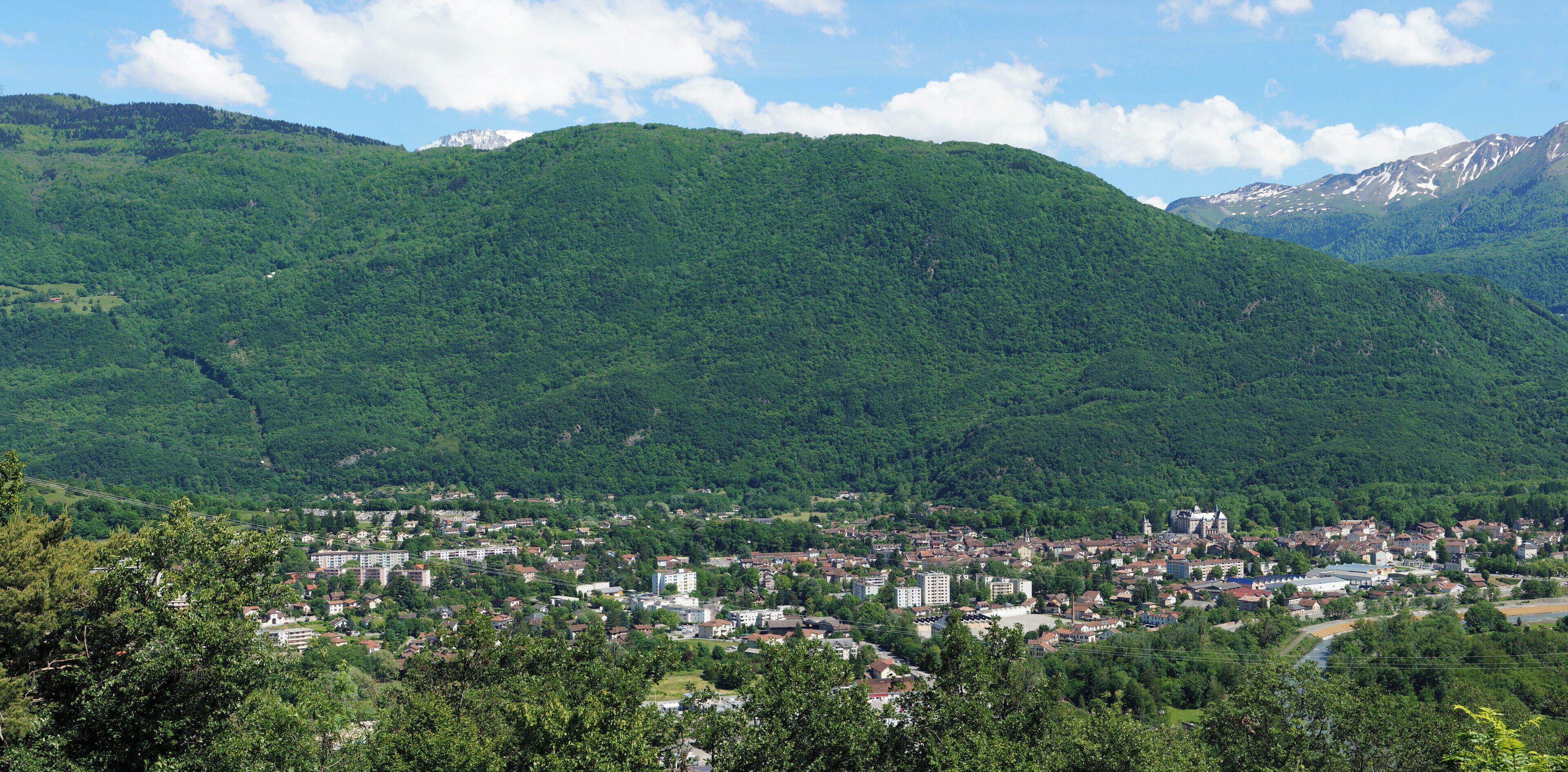 A town nestled in a valley with mountains in the background.