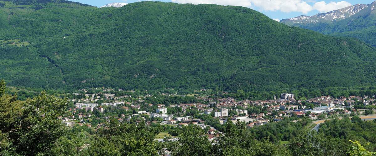 A town nestled in a valley with mountains in the background.