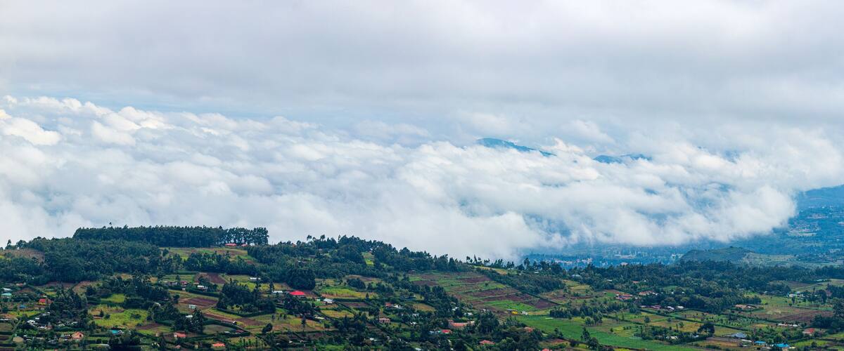 A mountainous landscape with a valley filled with small houses and lush greenery.